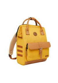 Gelber Canvas-Rucksack mit braunen Lederakzenten, oberen Griffen, verstellbarem Schulterriemen, einer vorderen Klappentasche und drei vertikalen Streifen.