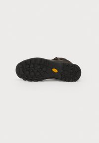 Kāpšanas zābaki ar melnu gumijas zoli ar dziļām brilēm, lai nodrošinātu saķeri, brūnu ādas augšdaļu ar auklām un izteiktu Vibram logotipu.