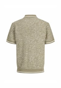 Polo en maille beige à manches courtes avec un motif géométrique subtil et un col, des poignets et un ourlet côtelés avec des accents de rayures blanches.