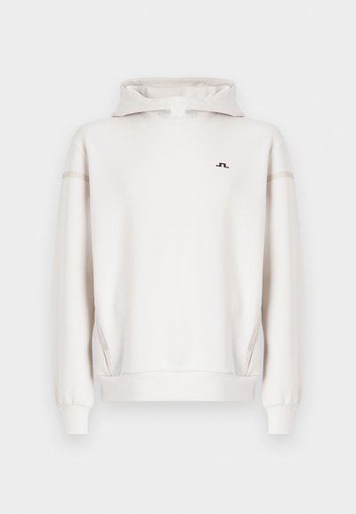 Λευκή φούτερ με κουκούλα και φερμουάρ στο μισό, με διακριτικό λογότυπο και αντίθετες ρίγες στα πλάγια. Κατασκευασμένη από λείο, υφασμάτινο υλικό με υφή.