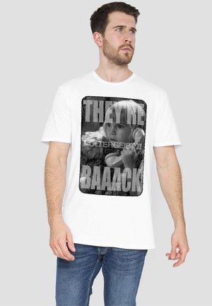 White cotton T-shirt featuring a black-and-white graphic print of a girl with headphones and bold text reading "THEY'RE BAAACK."