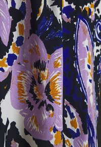 Tela con un gran patrón floral en morado, naranja, azul y negro sobre un fondo texturizado en color crema.