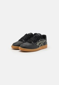 Sneaker in pelle nera con logo e dettagli grigi, punta rotonda, dettagli perforati e suola in gomma naturale. Design classico con lacci.