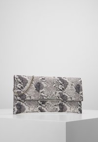 Pochette avec un motif imprimé serpent gris et blanc, dotée d'un accent en métal rectangulaire argenté et d'une bandoulière en chaîne métallique.