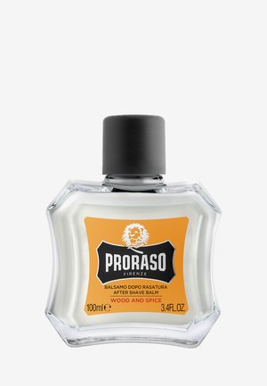 Balsam po goleniu Proraso w przezroczystej szklanej butelce, z czarną zakrętką i pomarańczową etykietą z białym i czarnym tekstem, 100 ml.