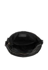 Black leather handbag open showing a large main compartment with a zippered pocket and an inner slip pocket.