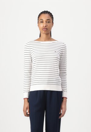Gestreiftes Langarmshirt in Weiß und Marineblau. Mit weitem Ausschnitt, gerippten Bündchen und kleinem, markiertem Logo auf der Brust. Aus weichem Baumwollmaterial.