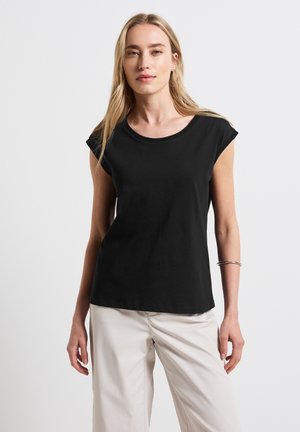 Black short-sleeve t-shirt with a round neckline, made from soft fabric. Features a smooth texture and a relaxed fit, worn with light-colored trousers.