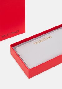 Valentino gray textured wallet with gold logo, placed inside a red box. The wallet features a sleek rectangular shape.
