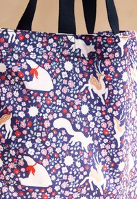 Tengerészkék táska fehér medvék, rókák, szarvasok mintájával, valamint piros, rózsaszín és fehér virágokkal. Fekete fogantyúk.