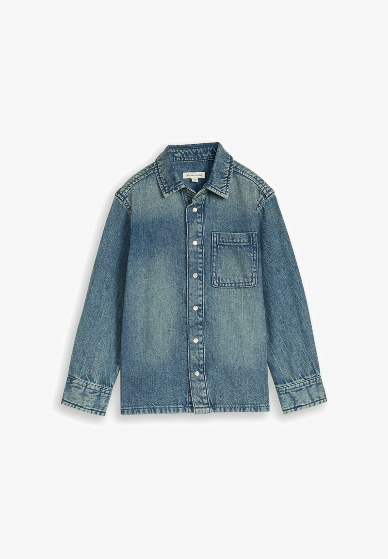 Chemise en denim bleu à boutons avec manches longues et une seule poche poitrine, posée à plat sur un fond blanc.