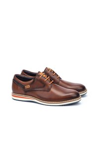Brown leather shoes with a smooth texture, contrasting orange laces, stitched accents, and a white-and-orange striped sole.