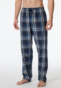 Un pantalon de lounge à carreaux bleu et gris avec une taille élastique et un cordon de serrage, fabriqué en coton doux et au design ample.