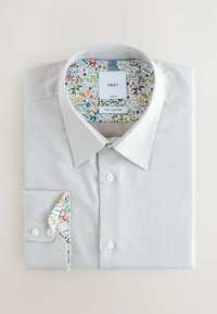 Világosszürke, 100% pamut ing texturált mintával. A gallér és az ingujj virágmintás béléssel díszített. Slim fit szabás gombokkal.