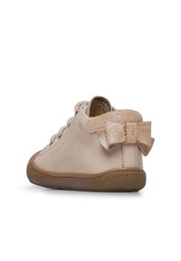 Ljust rosa lädersko med texturerad yta, rund tå, snörningsdesign och glänsande gyllene rosett vid hälen. Gummisulor med bra grepp.