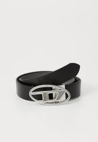Black leather belt with a shiny silver oval buckle featuring a geometric design and a flat strap. Smooth texture, minimalist style.