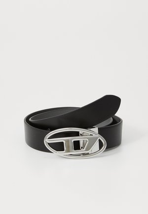 Black leather belt with a shiny silver oval buckle featuring a geometric design and a flat strap. Smooth texture, minimalist style.