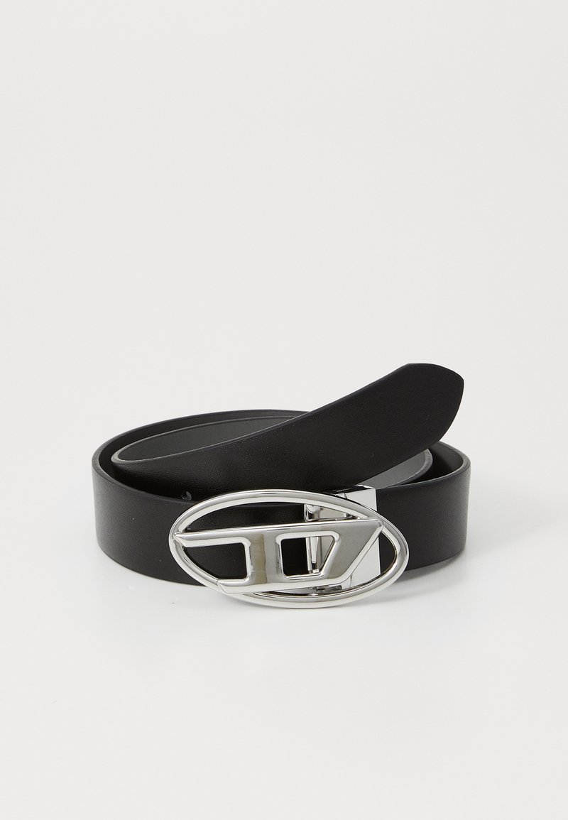 Black leather belt with a shiny silver oval buckle featuring a geometric design and a flat strap. Smooth texture, minimalist style.