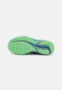 Laufschuhsohle mit einer strukturierten grünen Gummi-Außensohle mit Zickzackmuster, akzentuiert mit blauen Elementen und grauem Zwischensohl.
