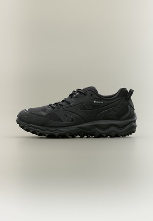 Czarny niski but sportowy z teksturowaną podeszwą, wiązany z przodu i etykietą Gore-Tex po boku, wyświetlany na neutralnym tle.