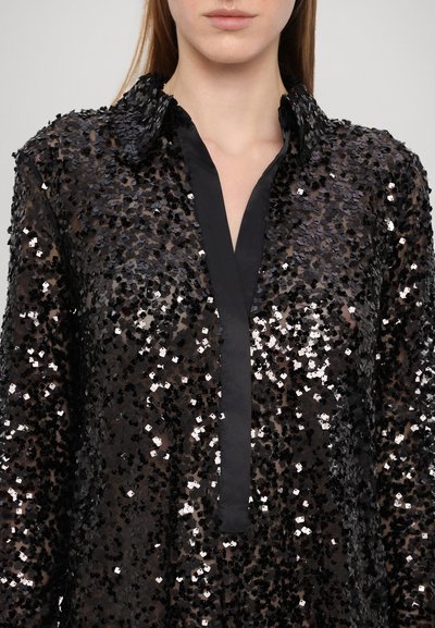 Black sequined shirt with a collared neckline and a placket. Features a textured surface with shiny sequin embellishments and sheer fabric.