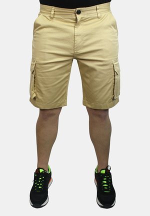 Pantaloni cargo color khaki con due tasche laterali, chiusura con bottone e taglio dritto. Il materiale ha una texture liscia. Abbinati a sneakers nere.