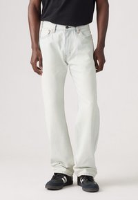 Jasnoniebieskie dżinsy o prostym kroju, z pięcioma kieszeniami, kontrastowym pomarańczowym przeszyciem i zapięciem na guzik.