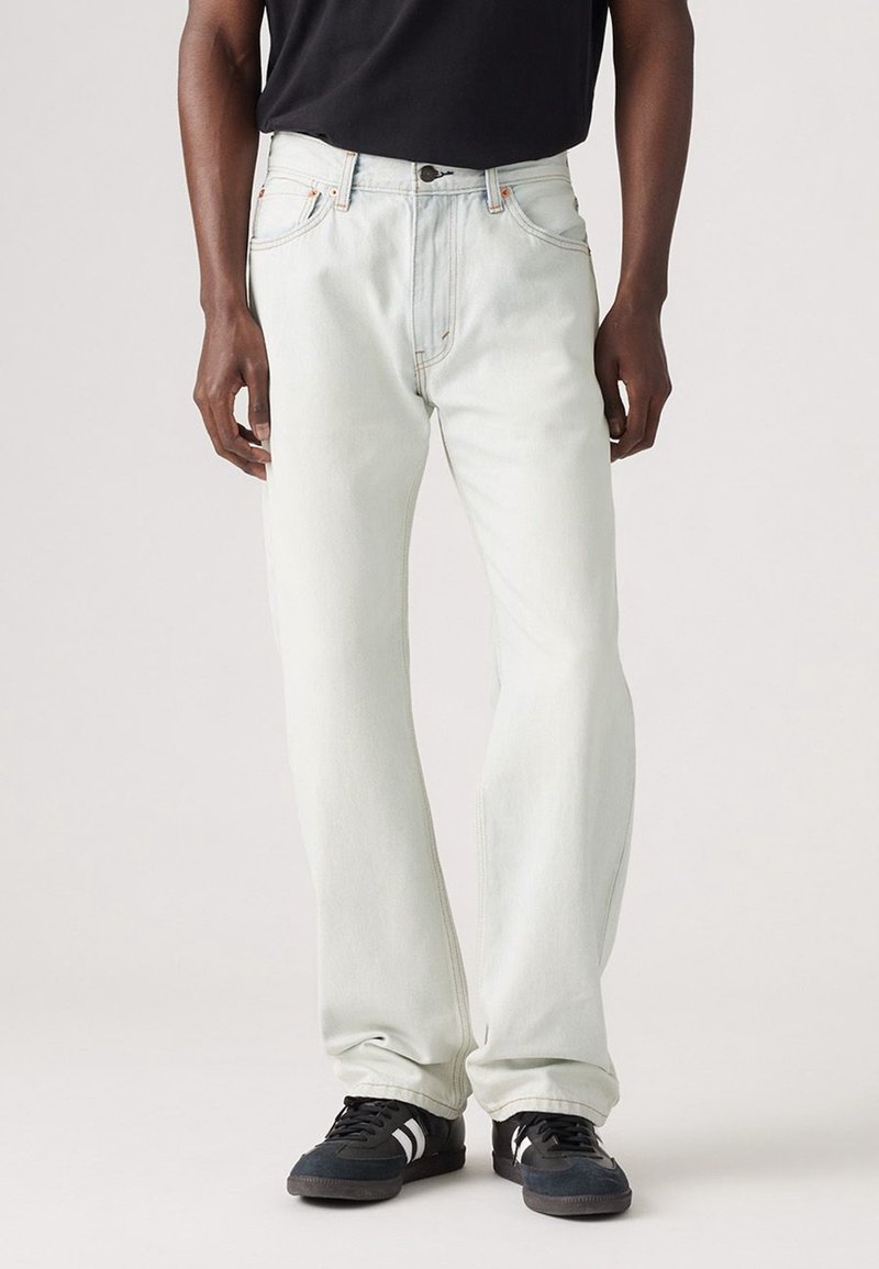 Jasnoniebieskie dżinsy o prostym kroju, z pięcioma kieszeniami, kontrastowym pomarańczowym przeszyciem i zapięciem na guzik.