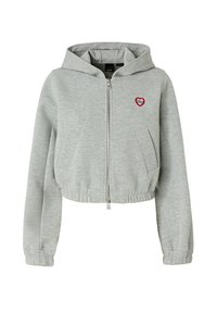 Felpa corta grigio chiaro con maniche lunghe, zip frontale, due tasche laterali e dettaglio di cuore rosso ricamato vicino alla spalla sinistra.