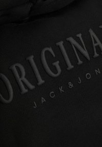 Černá mikina s kapucí s embosovaným nápisem "ORIGINAL" a logem "JACK & JONES", vyrobená z hladké tkaniny s jemnou texturou.