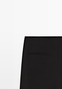 Black tailored skirt with a horizontal welt pocket on the right side, displayed against a white background.