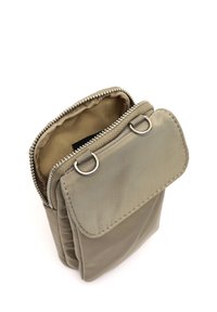 Alyvuogių spalvos nailono krepšys su užtrauktuku, turintis lankstų užverčiamą dangtį, pritvirtintą dviem metaliniais žiedais. Vidus išklotas smėlio spalvos.