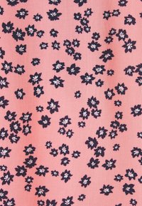 Tessuto floreale con sfondo rosa, caratterizzato da fiori blu scuro sparsi con centri bianchi. Texture simile al cotone, con motivo uniforme.