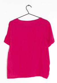 Krátký rukáv v jasně růžové barvě s kulatým výstřihem a uvolněným střihem. Vyrobeno z lehkého materiálu s hladkou strukturou.