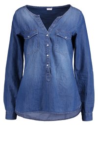 Chemise en denim à manches longues de couleur bleu foncé avec un col en V, une fermeture à boutons, deux poches poitrine et un ourlet arrondi. Texture douce avec une coupe décontractée.