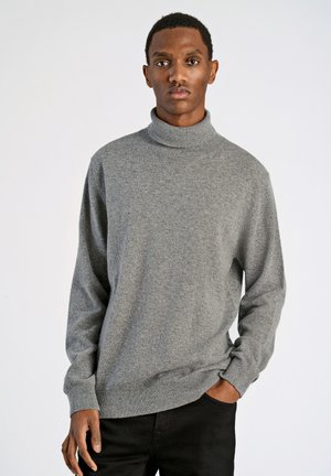 Suéter gris de cuello alto con mangas largas, hecho de una tela suave y texturizada. Presenta puños y dobladillo acanalados, combinado con pantalones negros.