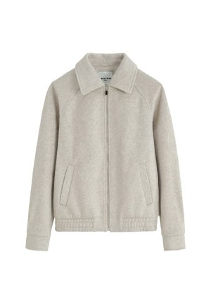 Veste en polaire beige clair avec fermeture éclair sur le devant, large col, manches longues, deux poches latérales et coutures décoratives à l'ourlet et aux poignets.