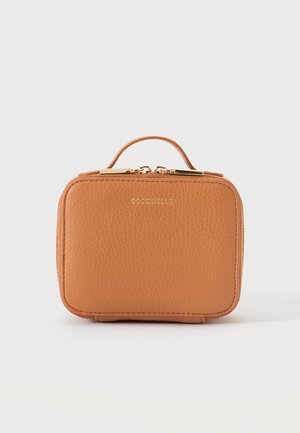 Piccola borsa a mano rettangolare in pelle color cuoio con manico superiore e cerniera oro, con il nome del marchio Coccinelle impresso in rilievo in lettere dorate.