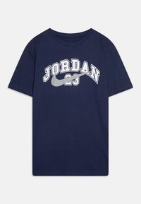 Temno modra bombažna majica s kratkimi rokavi, ki prikazuje napis "JORDAN" v belih ukrivljenih črkah in pod njim sivo ikono Nike swoosh. Ima krožni ovratnik.