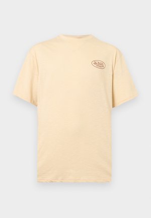 Camiseta beige de manga corta con cuello redondo y pequeño logotipo de "Von Dutch California" en la parte superior izquierda del pecho.