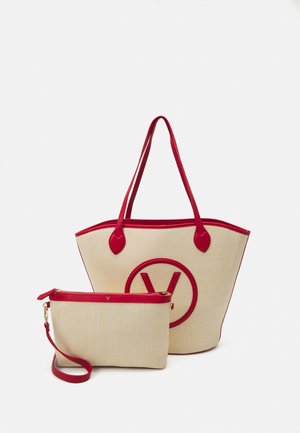 Große beige Tragetasche mit roten Akzenten und einem runden Logo; kombiniert mit einer kleineren Clutch, ebenfalls beige mit einem roten Reißverschluss und Trageriemen.
