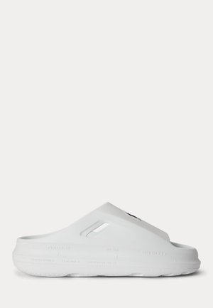 Άσπρο τσόκαρο χωρίς κορδόνια με κλειστή μύτη, οπές αερισμού στο πάνω μέρος και υφή στην σόλα για καλύτερη πρόσφυση, εμφανίζεται από την πλευρά σε απλό φόντο.