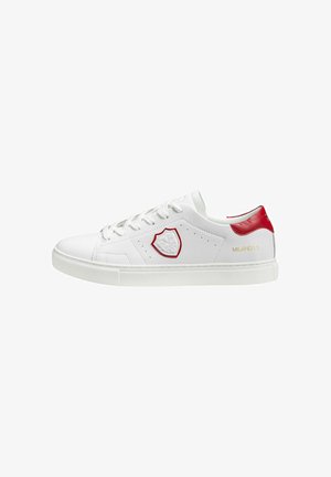 White leather sneakers with red accents, featuring a stitched emblem, round toe, and flat rubber sole. Text reads "MILANO1.1" in gold.