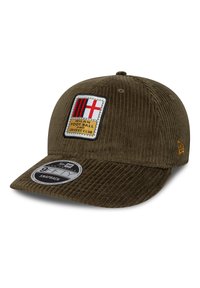 Cappello in corduroy verde oliva con visiera piatta, dotato di un patch ricamato con accenti rossi e bianchi e un bordo nero. Chiusura snapback.