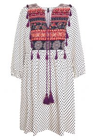 Vit långärmad klänning med svart tårformad mönster, flerfärgad broderad krage och lila tofsbindningar vid halsringning och sidor.
