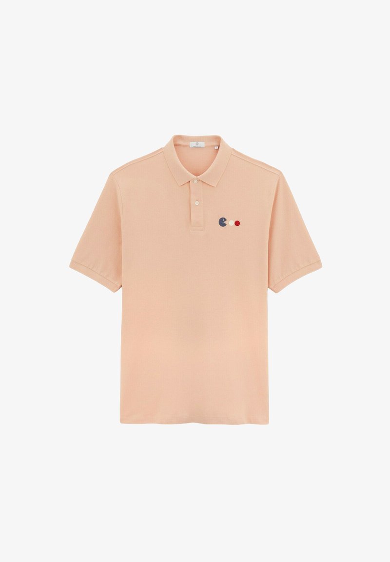 Perzikkleurig polo shirt met een kraag, korte mouwen en drie gekleurde stippen (blauw, rood en wit) geborduurd op de linkerborst.