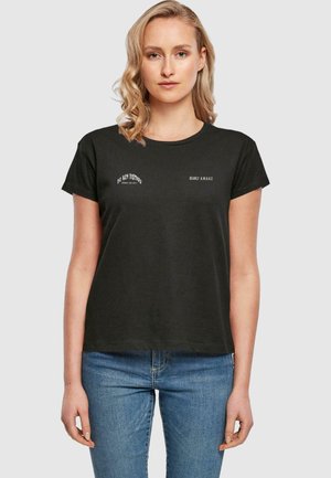 Sort bomulds t-shirt med korte ærmer, der har hvide tekstgrafikker "FORSTYR IKKE" og "NÆSTEN VåGEN" på forsiden. Simpelt design.