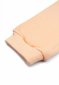 Lichtroze katoenstof met een geribde manchet, een gladde textuur en een nette rand, ontworpen voor comfort en gemakkelijk dragen.