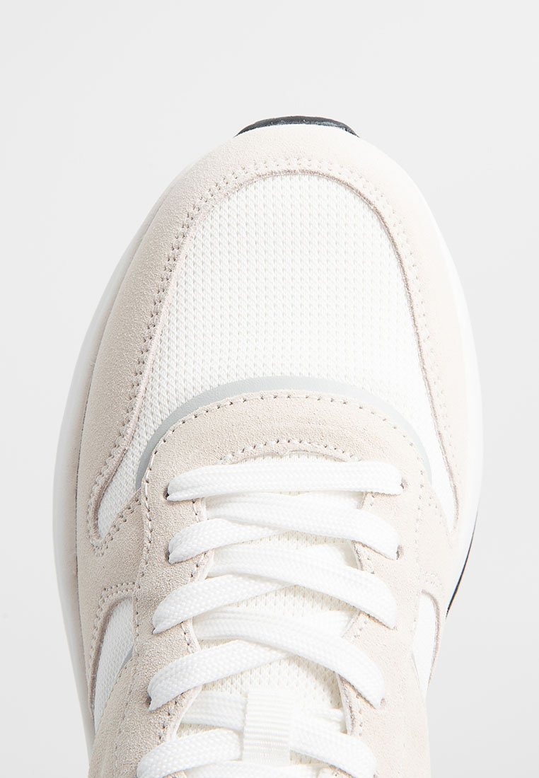 Helle beigen Sneaker mit einem Obermaterial aus strukturiertem Stoff, Wildlederakzenten, weißen Schnürsenkeln und einer runden Zehenpartie. Verfügt über eine schwarze Sohle und glatte Kanten.
