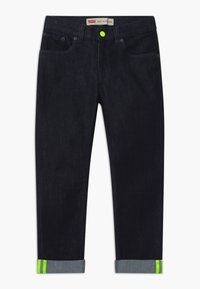 Dark blue denim jeans with a slim fit, featuring a neon green accent at the rolled cuffs, contrasting stitching, and front pockets.